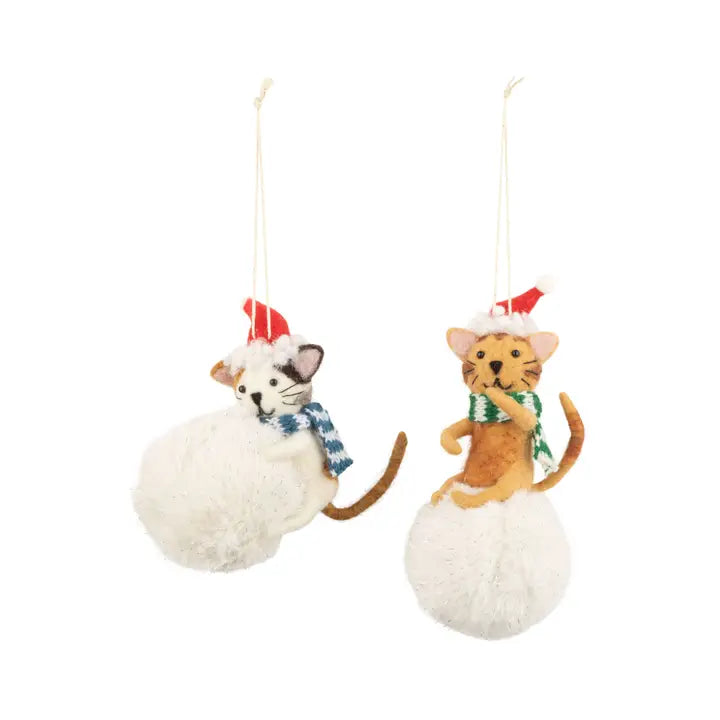 Christmas ornaments of a cat on snowball with scarves and hats on a white background.
