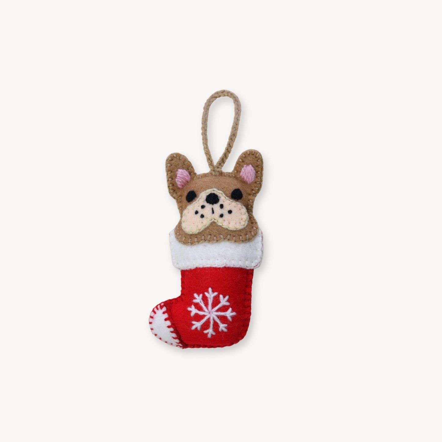 Dog-shaped Christmas ornament in a red stocking with a snowflake design on a white background